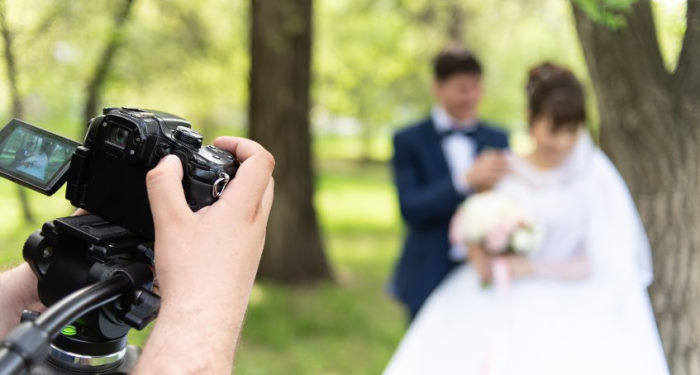 videographer taking video and photos of married couple